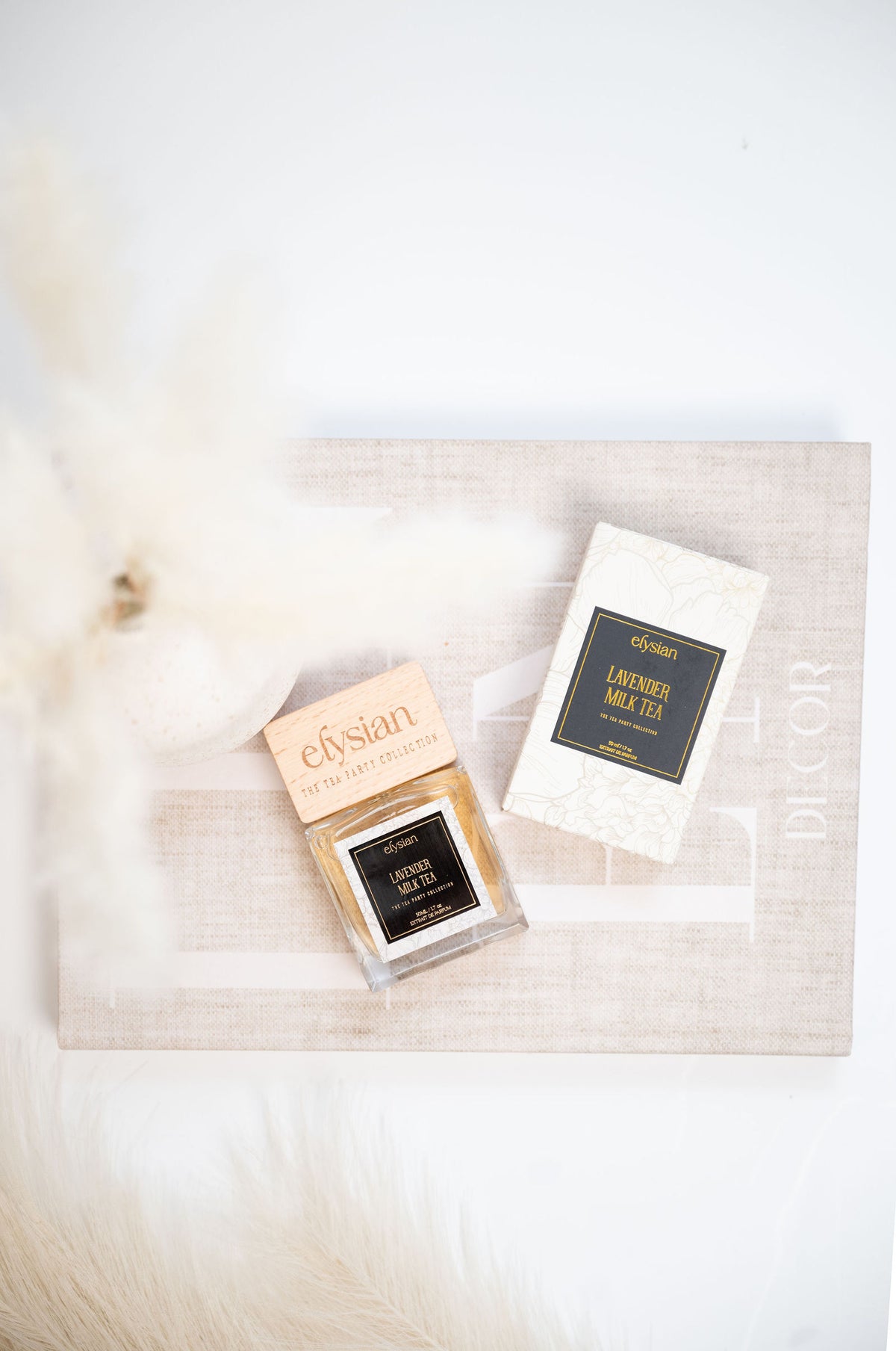 Lavender Milk Tea and its box on cream linen